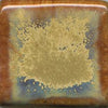 A golden cream glaze with reddish brown streaks. Can show blue crystals and varies widely in color and finish. Amaranth Stoneware Canada.