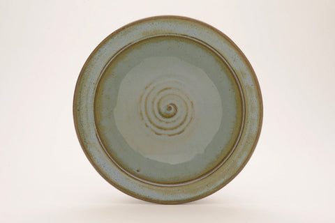 Arctic Blue glaze, a glossy, opaque light blue on white clay, and green-blue on red clay, breaks brown over texture. Amaranth Stoneware Canada.