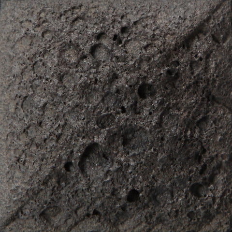 Cone 6: Charcoal-colored, high-texture glaze creating a rough, cratered surface; texture slightly flattens at Cone 10 with no color change. Amaranth Stoneware Canada.