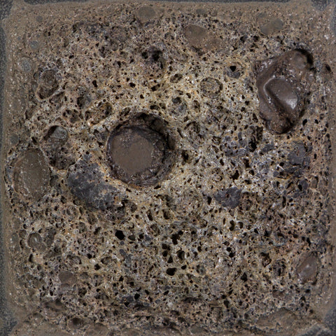 Cone 6: Charcoal-colored, high-texture glaze creating a rough, cratered surface; texture slightly flattens at Cone 10 with no color change. Amaranth Stoneware Canada.