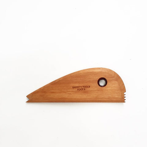 Foot 5 tool with rounded curve for supporting shapes and creating pointed or ridged feet. Flat bottom for stability and textured feet while spinning. 5.5