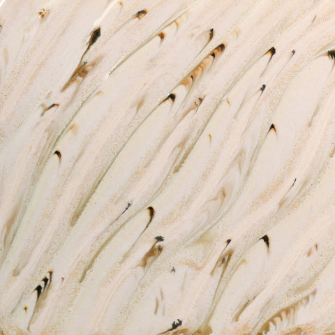 Glossy cream glaze with runny dark specks, breaking on texture with peachy float, great for layering. Amaranth Stoneware Canada.