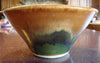 A golden cream glaze with reddish brown streaks. Can show blue crystals and varies widely in color and finish. Amaranth Stoneware Canada.
